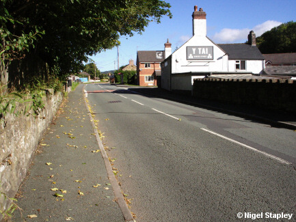 Photo of a road with a pub on the right-hand side