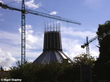 Picture of a concrete cathedral tower surrounded by cranes