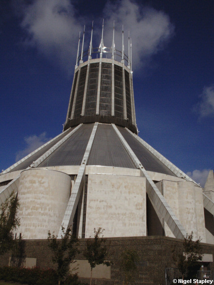 Picture of a concrete cathedral tower with a concrete belfry in front of it