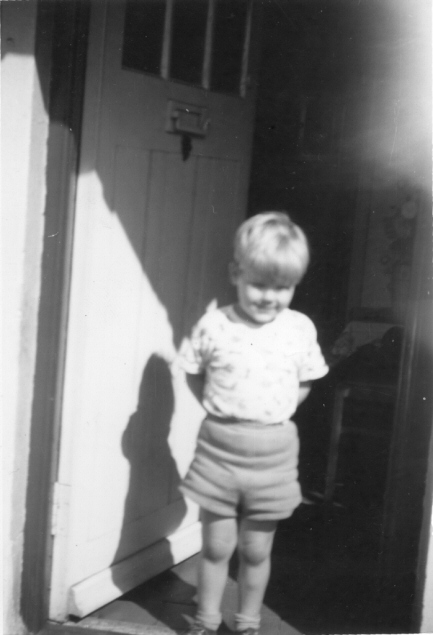Picture of small boy standing by a front door