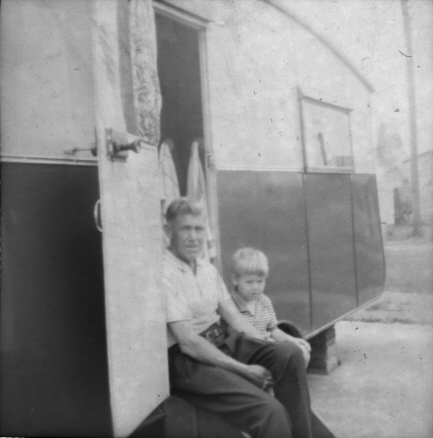 Picture of a man and a small boy sitting on the steps of a caravan