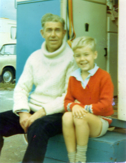 Picture of man and boy sitting on the steps of a caravan