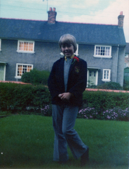 Photo of a boy dressed in a blazer and with a carnation buttonhole
