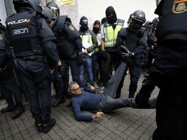 Photo of Spanish cops dragging a man along the pavement