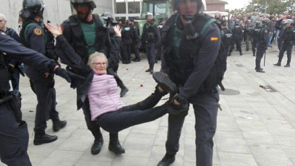 Photo of Spanish cops dragging an elderly woman