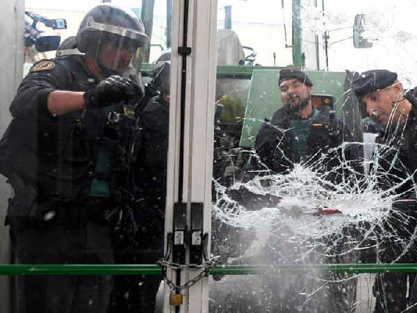 Photo of Spanish cops trying to smash their way into a television studio