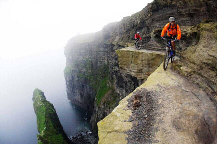 Photo of men riding bikes along a cliff ledge