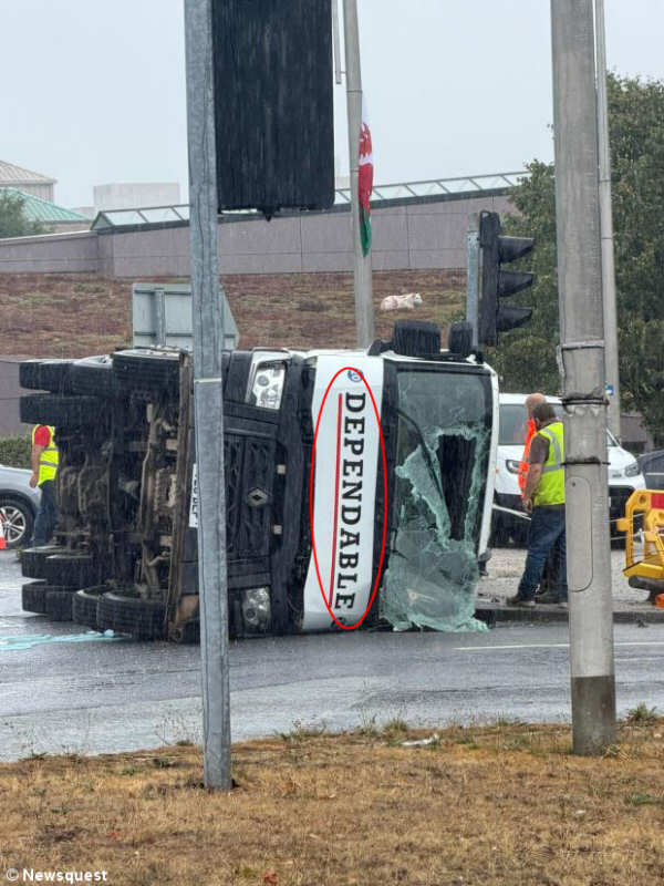 Photo of lorry crashed onto its side, with 'DEPENDABLE' written across the front