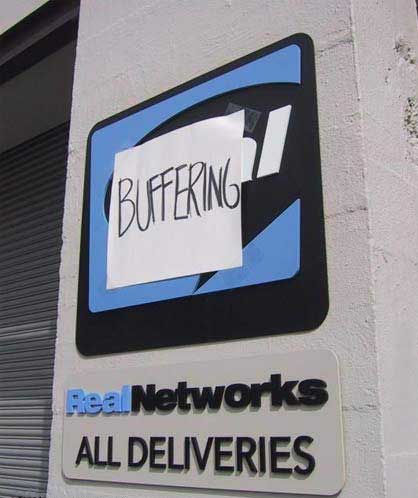 Sign outside of Real Networks' office to which someone has stuck a sheet of paper which reads 'Buffering'