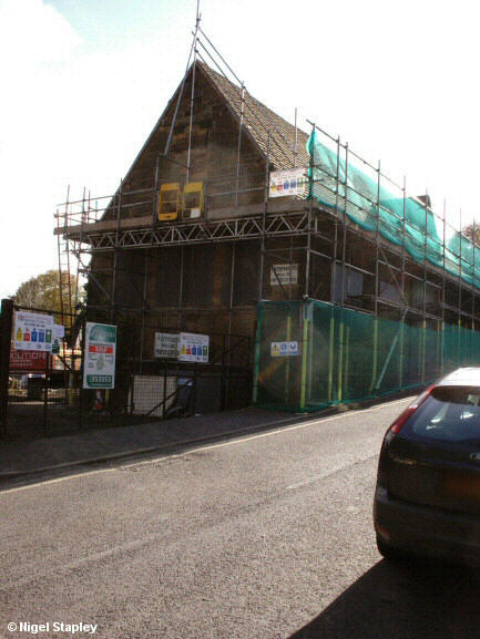 Photo of the gable end of an old sandstone school building with scaffolding around it