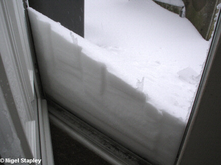 Snow piled up against a door