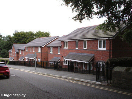 Photo of a row of new houses along the side of a road