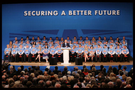 Photo of Tory Party rally with group of identically-dressed people with the backdrop slogan 'Securing A Better Future'